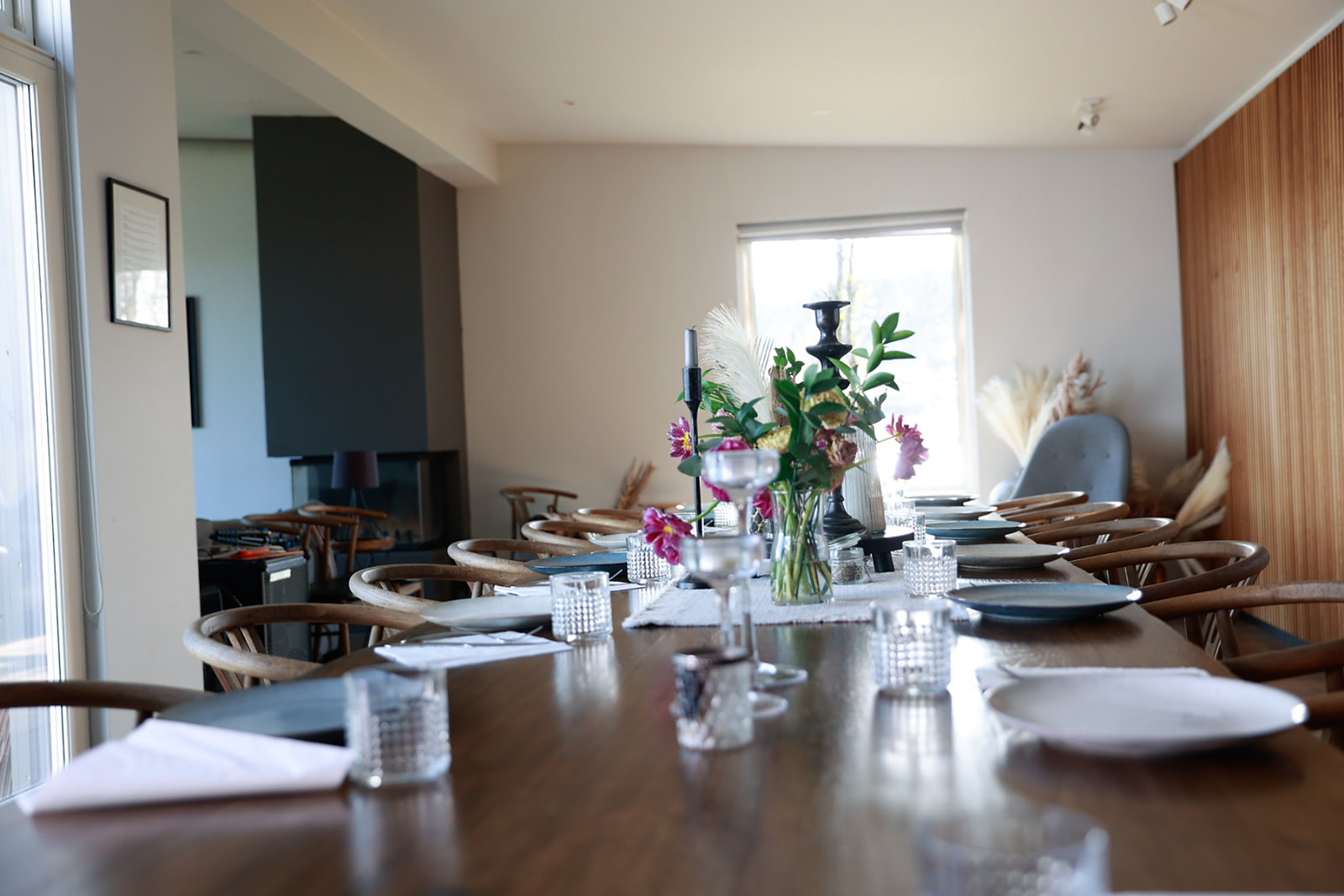 The lake-house dining table set with flowers and candles