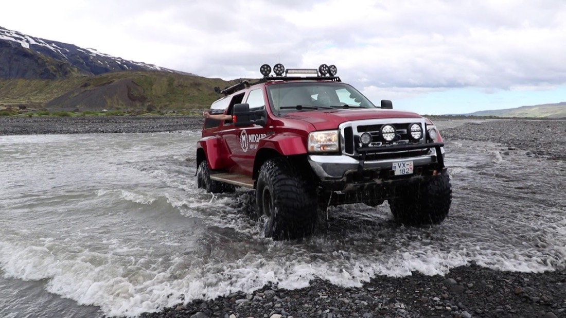 A Super Jeep crossing a glacial river